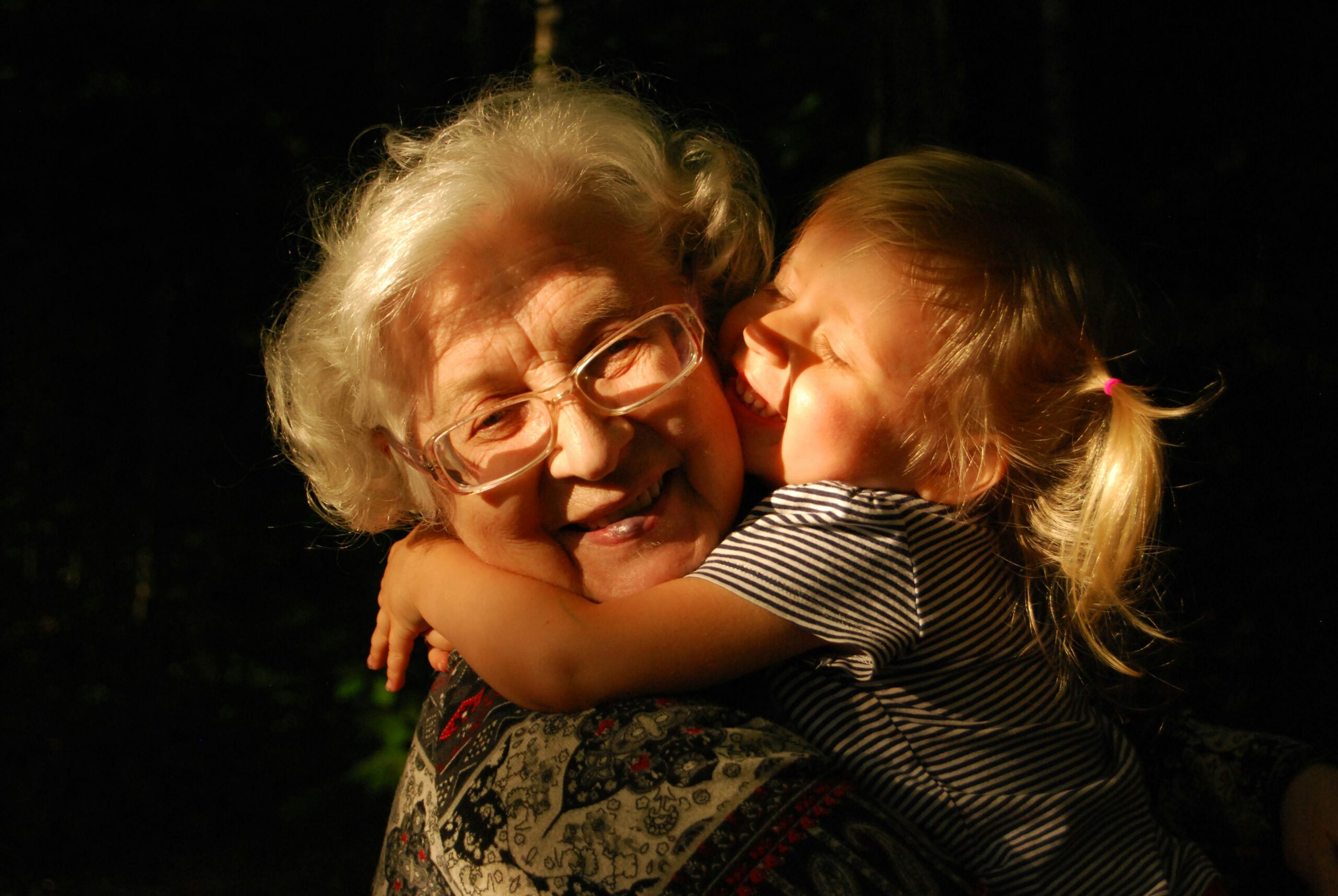 An older woman and a young girl enjoying a heartfelt hug